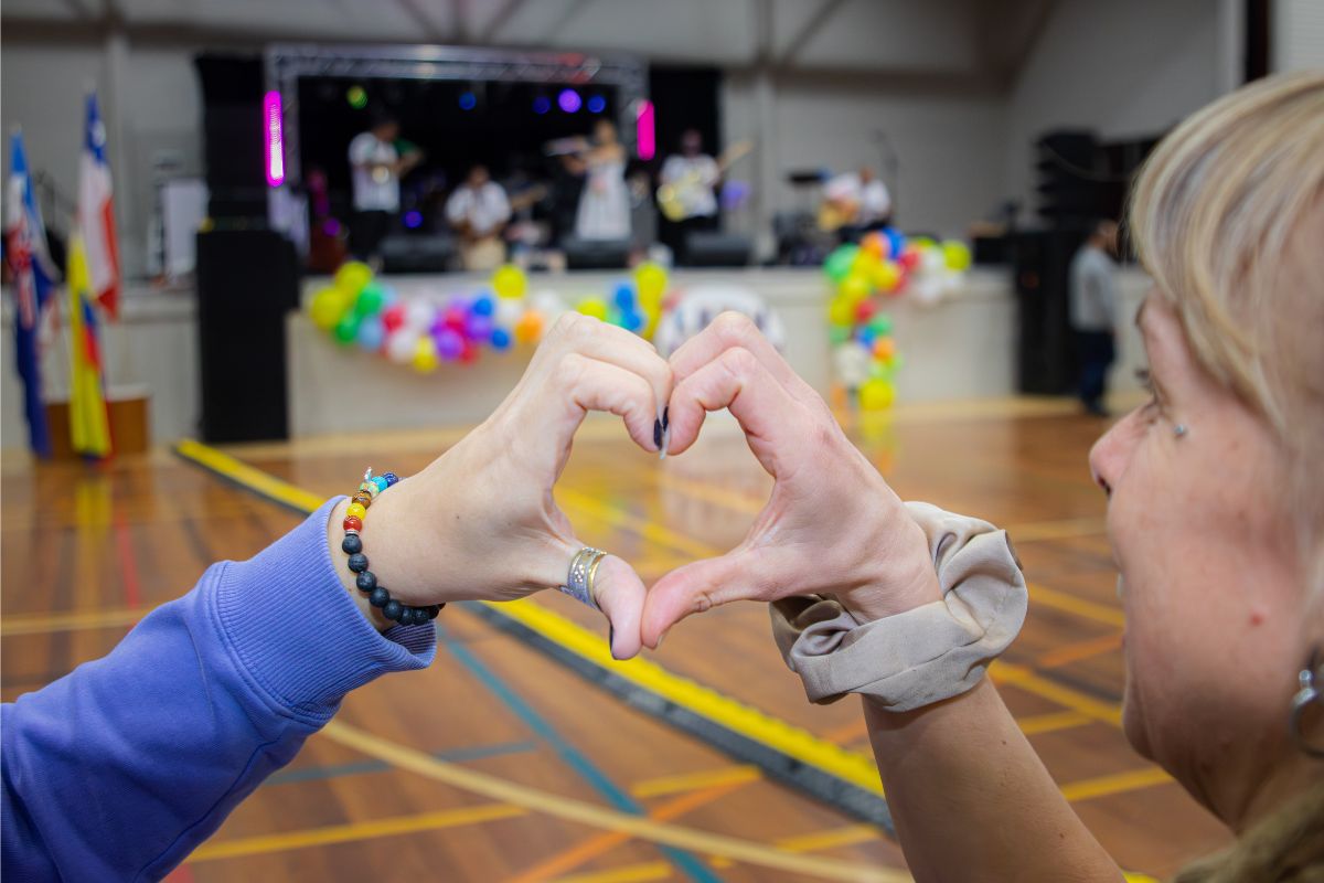 Volunteer forming a heart shape with their hands during the festival